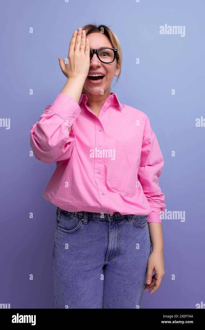 Giovane donna d'affari bionda, sorpresa e con sfondo isolato in camicia rosa Foto Stock