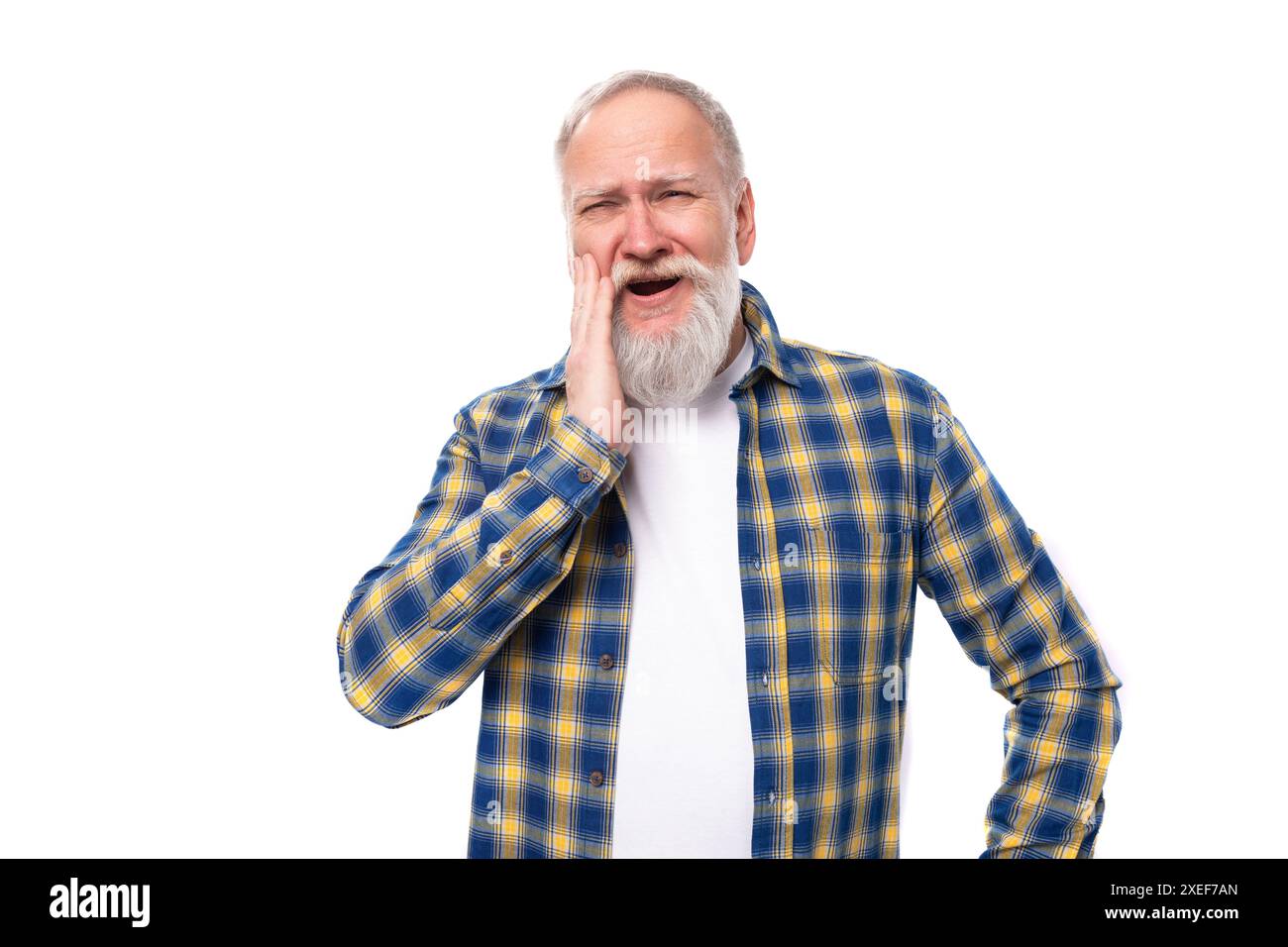 60s uomo di mezza età dai capelli grigi con barba in camicia fa un volto su sfondo bianco Foto Stock