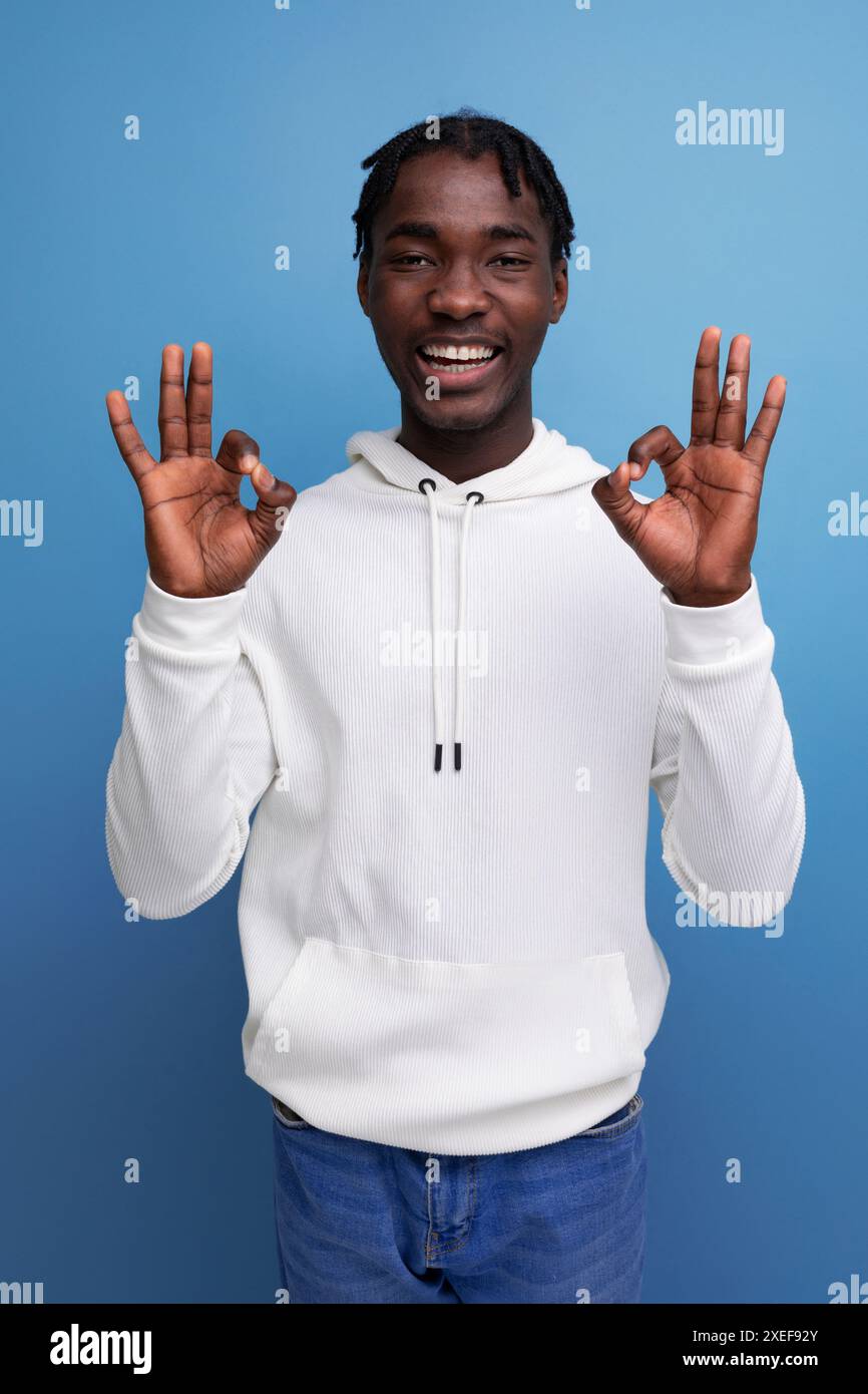Positivo giovane bruna dalla pelle scura con un sorriso di hollywood su sfondo isolato in studio Foto Stock