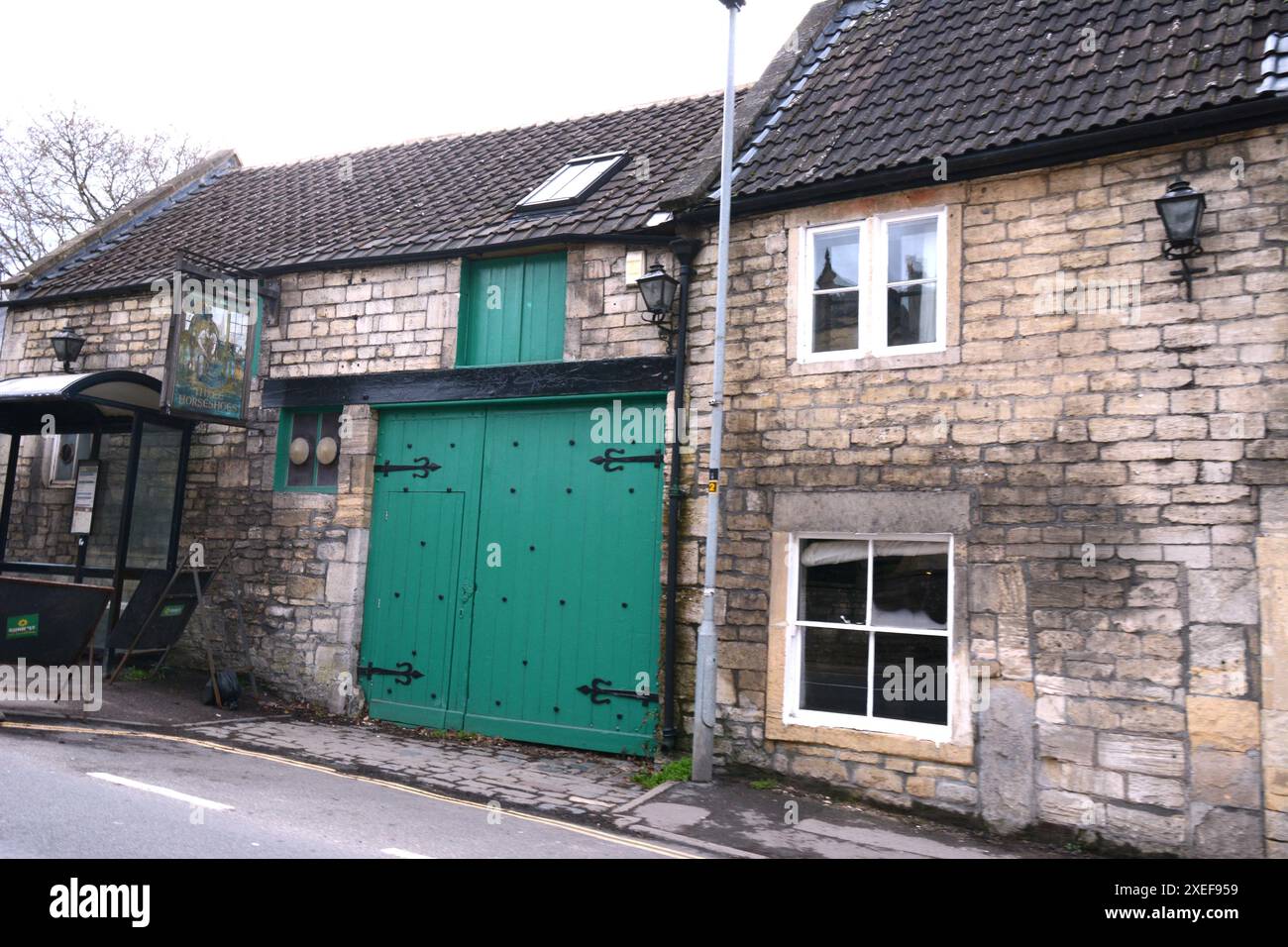 Village Bradford on Avon garage dipinto verde vecchio stile cottage in pietra edificio storico chiuso porta luci fienile cerniere finestre sentiero Foto Stock