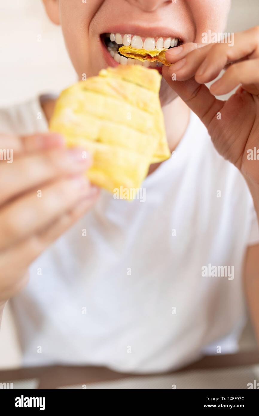 Giovane donna che prende un boccone di fast food fatto in casa Foto Stock