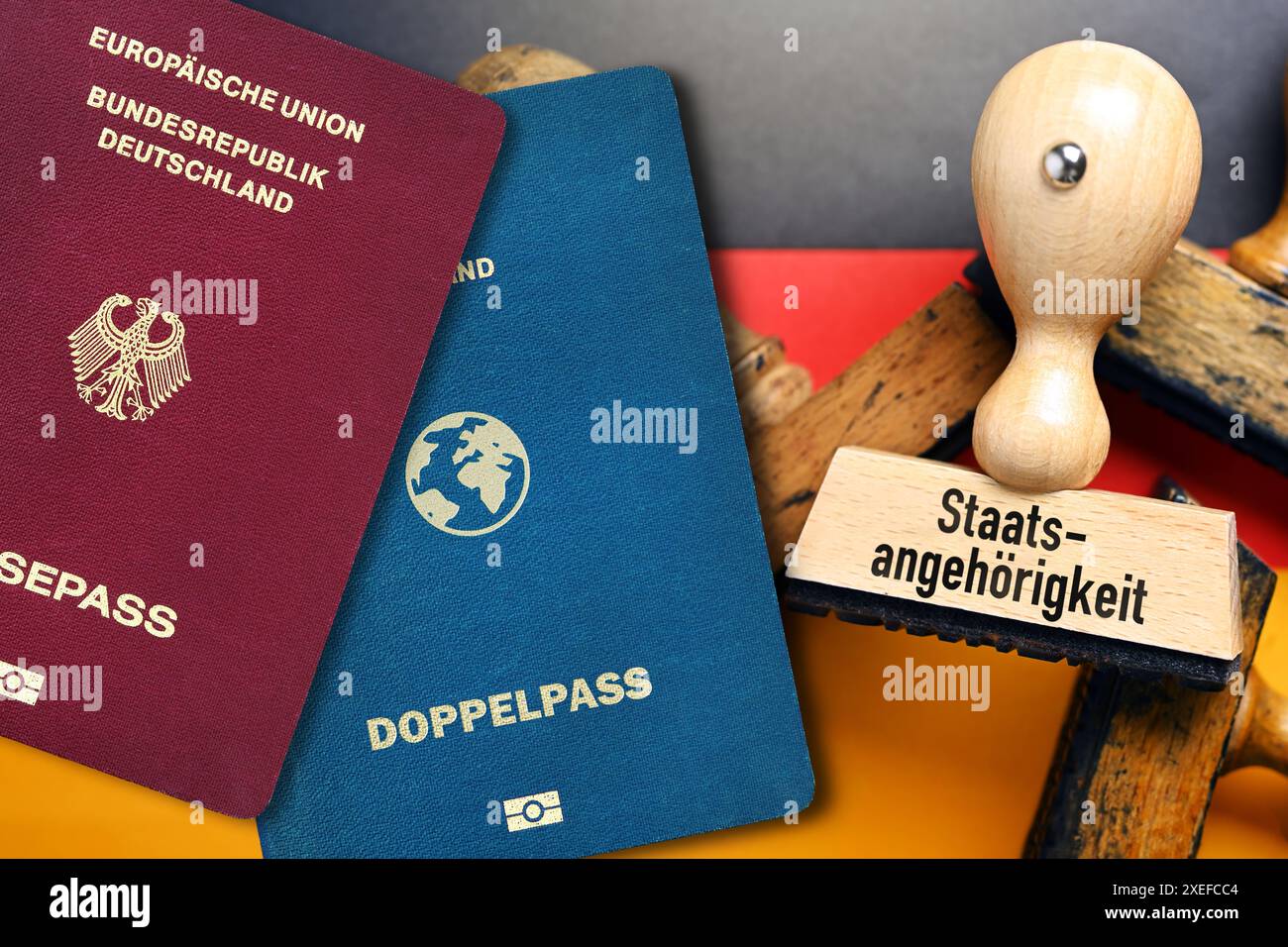 FOTOMONTAGE, Stempel mit Aufschrift Staatsangehörigkeit auf deutscher Fahne und Doppelpass, Gesetz zur Modernisierung des Staatsangehörigkeitsrechts *** FOTOMONTAGGIO, timbro con iscrizione cittadinanza sulla bandiera tedesca e doppio passaporto, legge per modernizzare la legge sulla cittadinanza Foto Stock