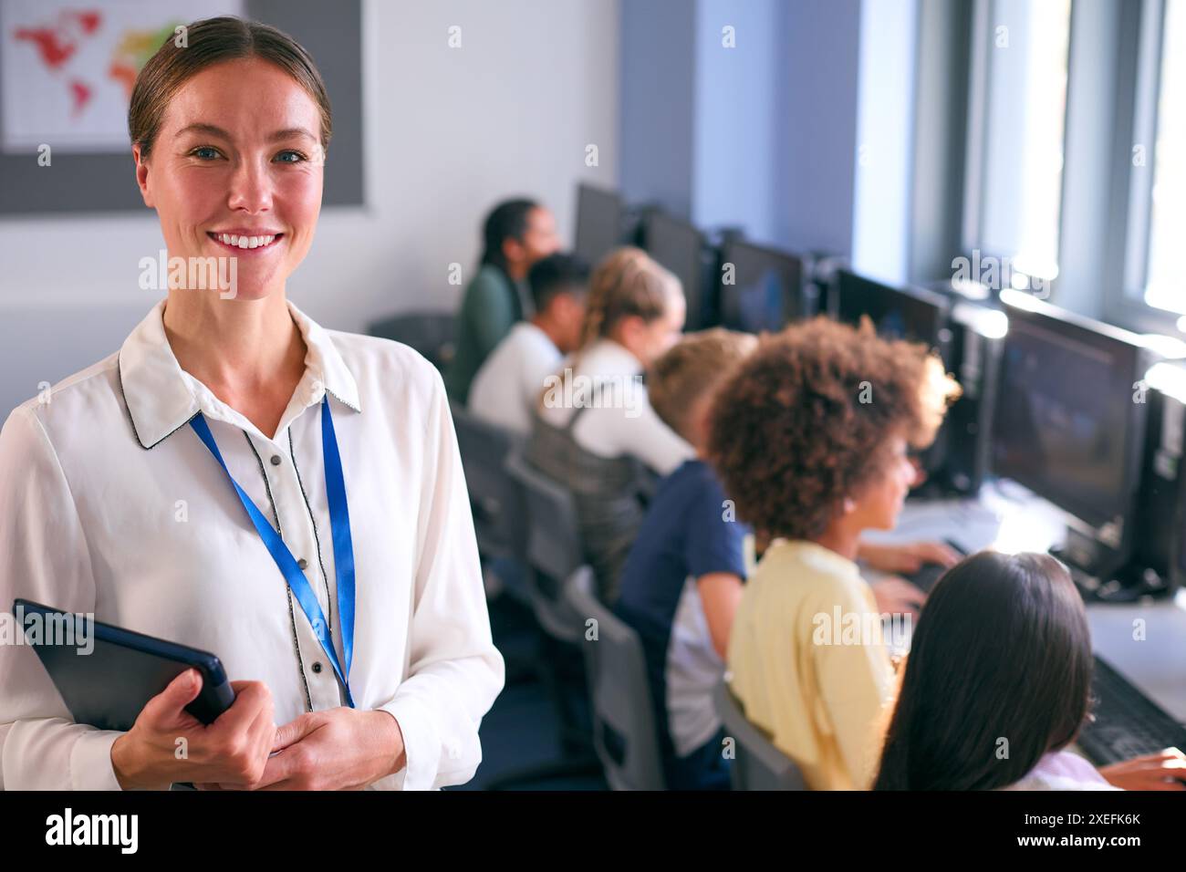 Ritratto di insegnante femminile di scuola secondaria o superiore con studenti di computer in classe IT Foto Stock
