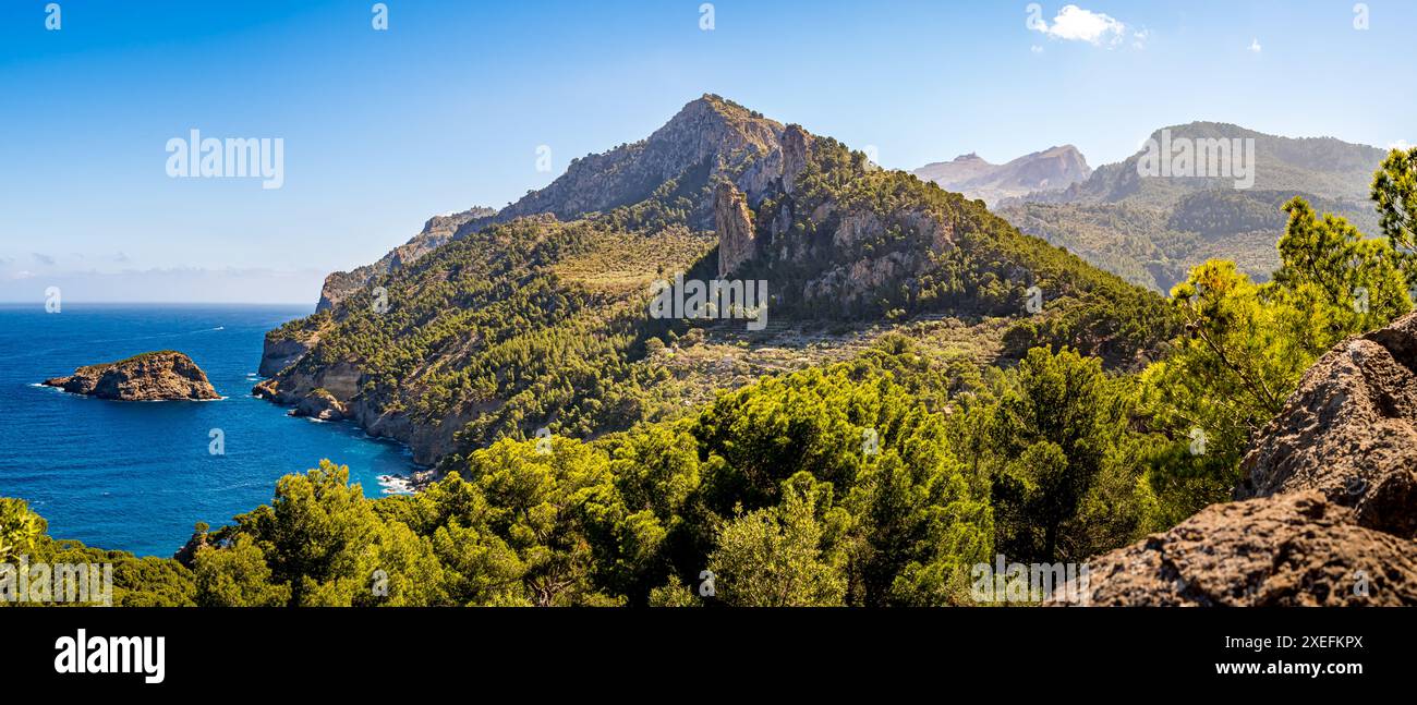 Vista sulla costa di Maiorca all'insenatura di Cala Ses Cambres e sul picco della catena montuosa Serra de Tramuntana Puig de Bàlitx in una giornata di sole con es Penyal Bernat. Foto Stock