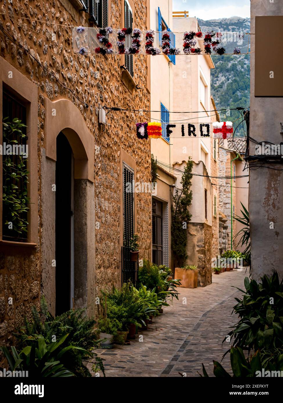 Vicolo decorato a Sóller con piante in vaso e ghirlande che recitano "Sóller Firó" per il festival dei pirati Firó de Sóller che celebra una storica vittoria. Foto Stock