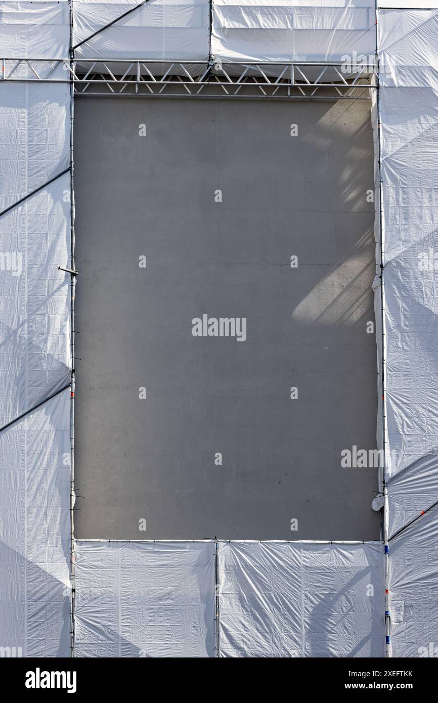 L'impalcatura rivestita con pellicola di plastica sulla parete della casa ha un'apertura Foto Stock