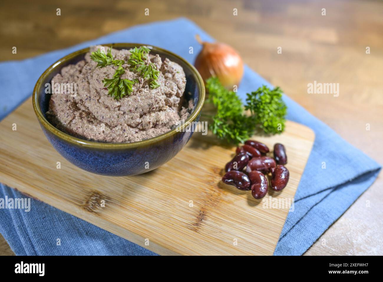 Alternativa vegetariana e vegana per il patato epatico a base di piante come fagioli renali, tofu, cipolla ed erbe, sana diffusione in una ciotola su un tavolo da cucina Foto Stock