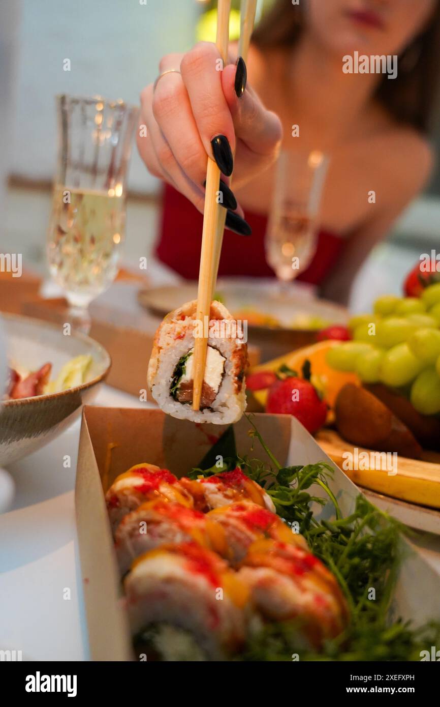 Sushi, amici e ristorante bramano con champagne per festeggiare il compleanno o un evento sociale. Festeggia il brindisi, felice e sorridi Foto Stock