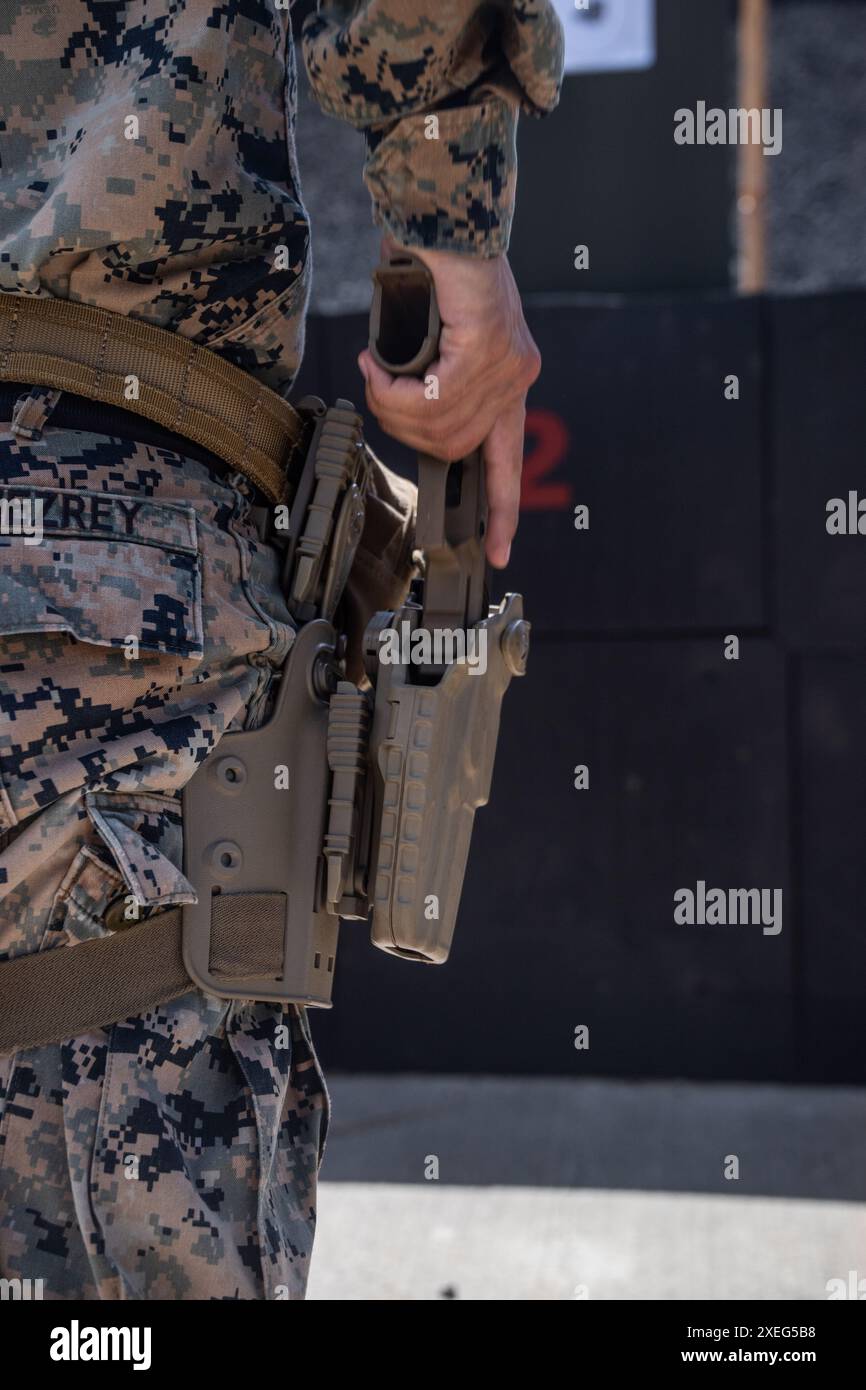 Henry GomezRey disegna una pistola M9 durante un poligono di tiro a fuoco vivo presso la Marine Corps base Hawaii, 20 giugno 2024. Marine del 3d Marine Littoral Regiment, della 3d Marine Division e delle Marine Corps Forces, il team di tiro di Pacific si è riunito per condurre un raggio di tiro dal vivo per rafforzare la competenza attraverso la velocità e la precisione nell'ambito delle armi leggere. GomezRey è un Marine di fanteria con 3d Marine Littoral Regiment, 3d Marine Division, ed è nativo di Falls Church, Virginia (foto del corpo dei Marines degli Stati Uniti del Sgt. Grace Gerlach) Foto Stock