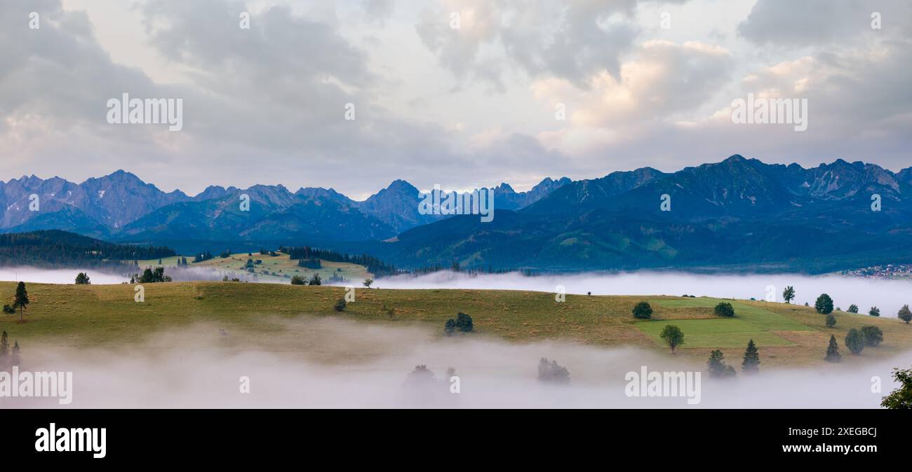 Sunrise e estate montagna nebbioso panorama del paese Foto Stock