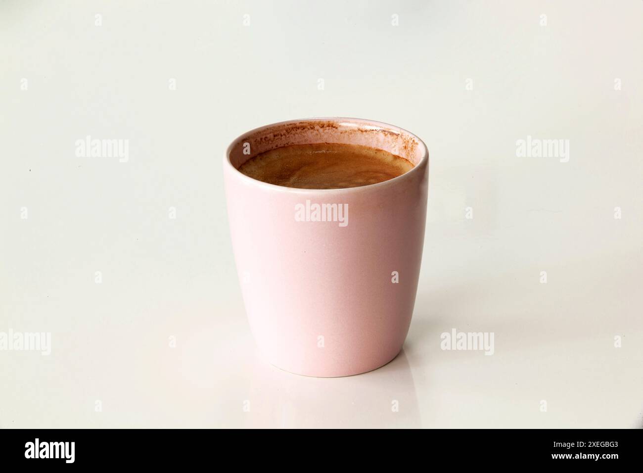 Tazza da caffè rosa con cappuccino o latte con schiuma isolata su sfondo bianco. Primo piano Foto Stock