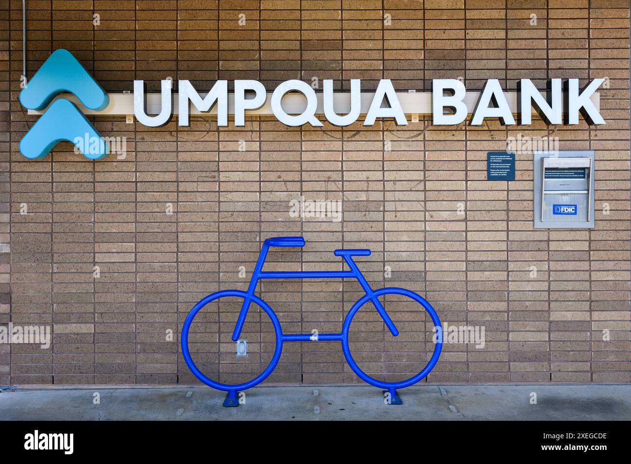 Silverton, OREGON, USA - 24 aprile 2024; firma presso Umpqua Bank sul muro di mattoni con logo e grafica della bicicletta Foto Stock