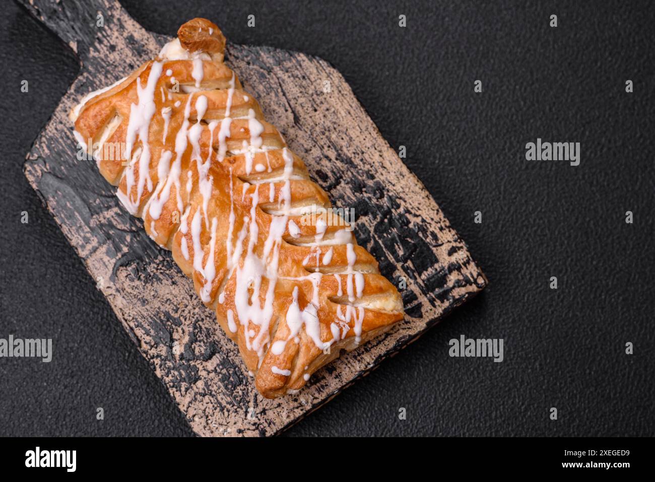 Delizioso panino intrecciato croccante con uvetta all'interno e glassa bianca all'esterno Foto Stock