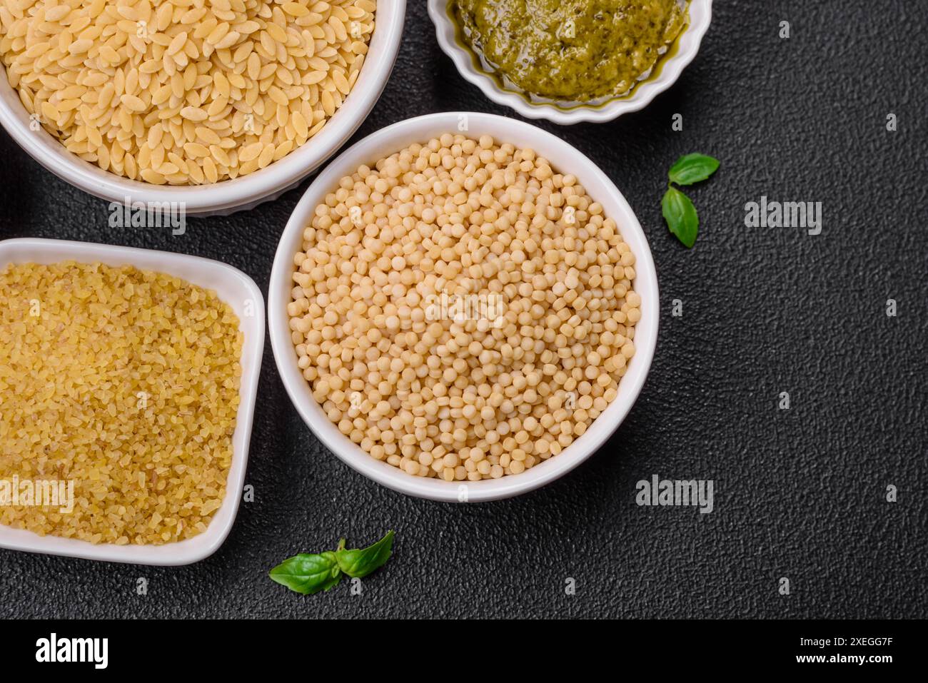 Crudo di pasta orzo integrale come ingrediente per un piatto delizioso. Piatto di cucina mediterranea Foto Stock