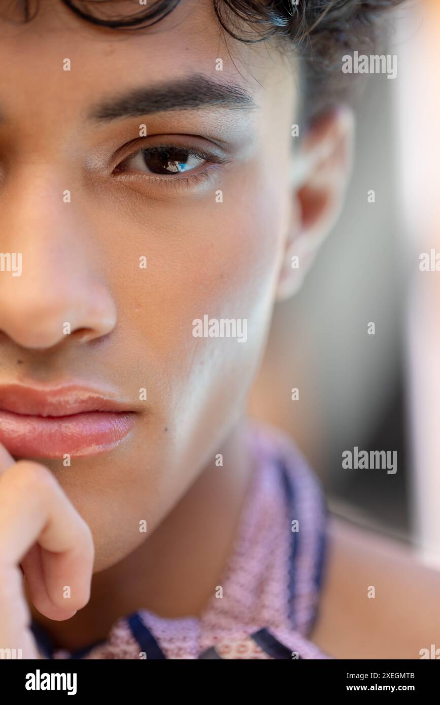 Primo piano di una donna transgender dall'espressione premurosa, con sciarpa a motivi geometrici Foto Stock