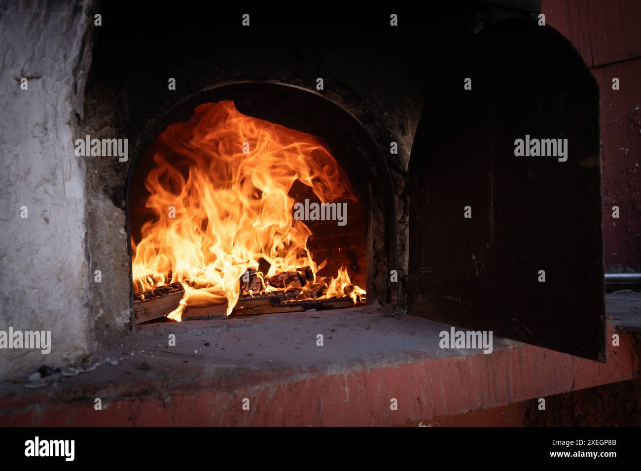 Fuoco e combustione di carboni nel forno a pietra. Forno in mattoni e argilla. Foto Stock