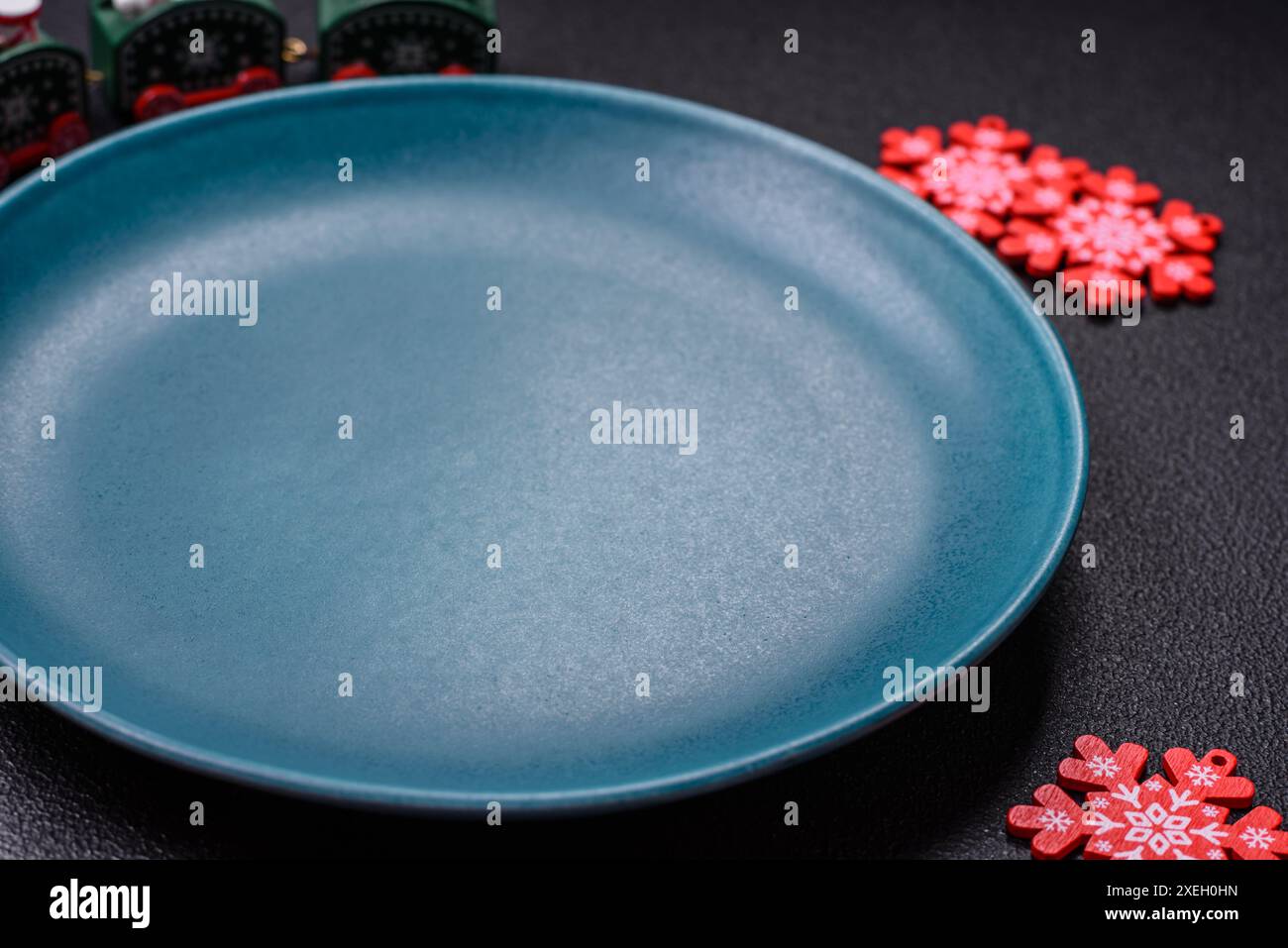 Piatto rotondo in ceramica decorato con elementi festivi sul tavolo di Natale. Prepararsi per la celebrazione del nuovo anno Foto Stock