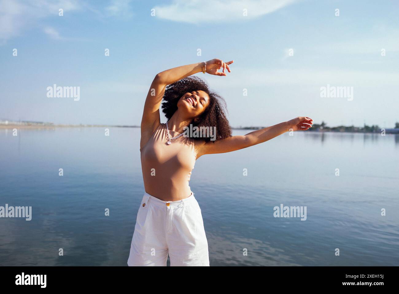 Primo piano ritratto di felice ragazza afro-americana sorridente dolcemente alla fotocamera Foto Stock