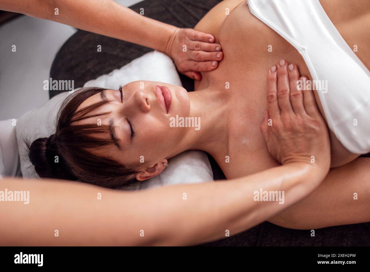Primo piano del ritratto di una giovane bella donna che riceve un massaggio al collo e alle spalle. Foto Stock