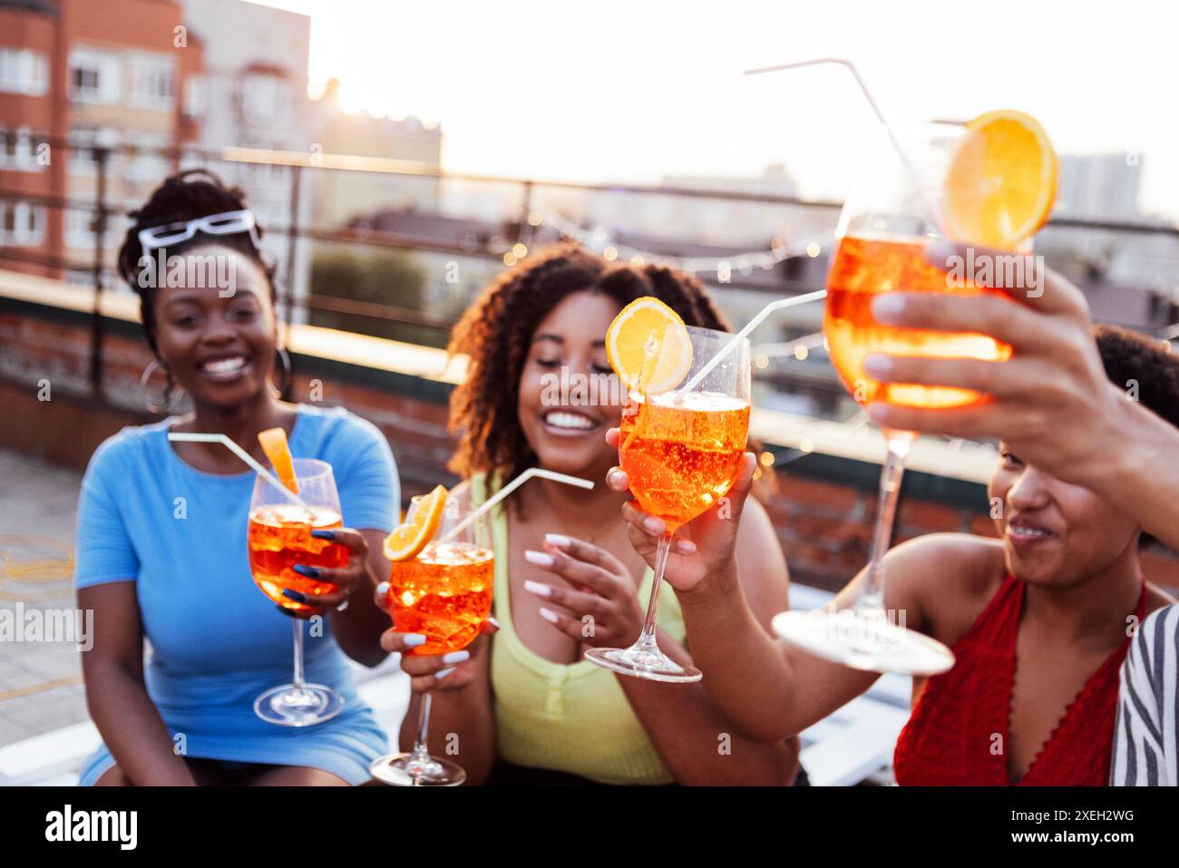 In compagnia di quattro amici allegri si gusteranno gustosi cocktail. Festa sul tetto Foto Stock