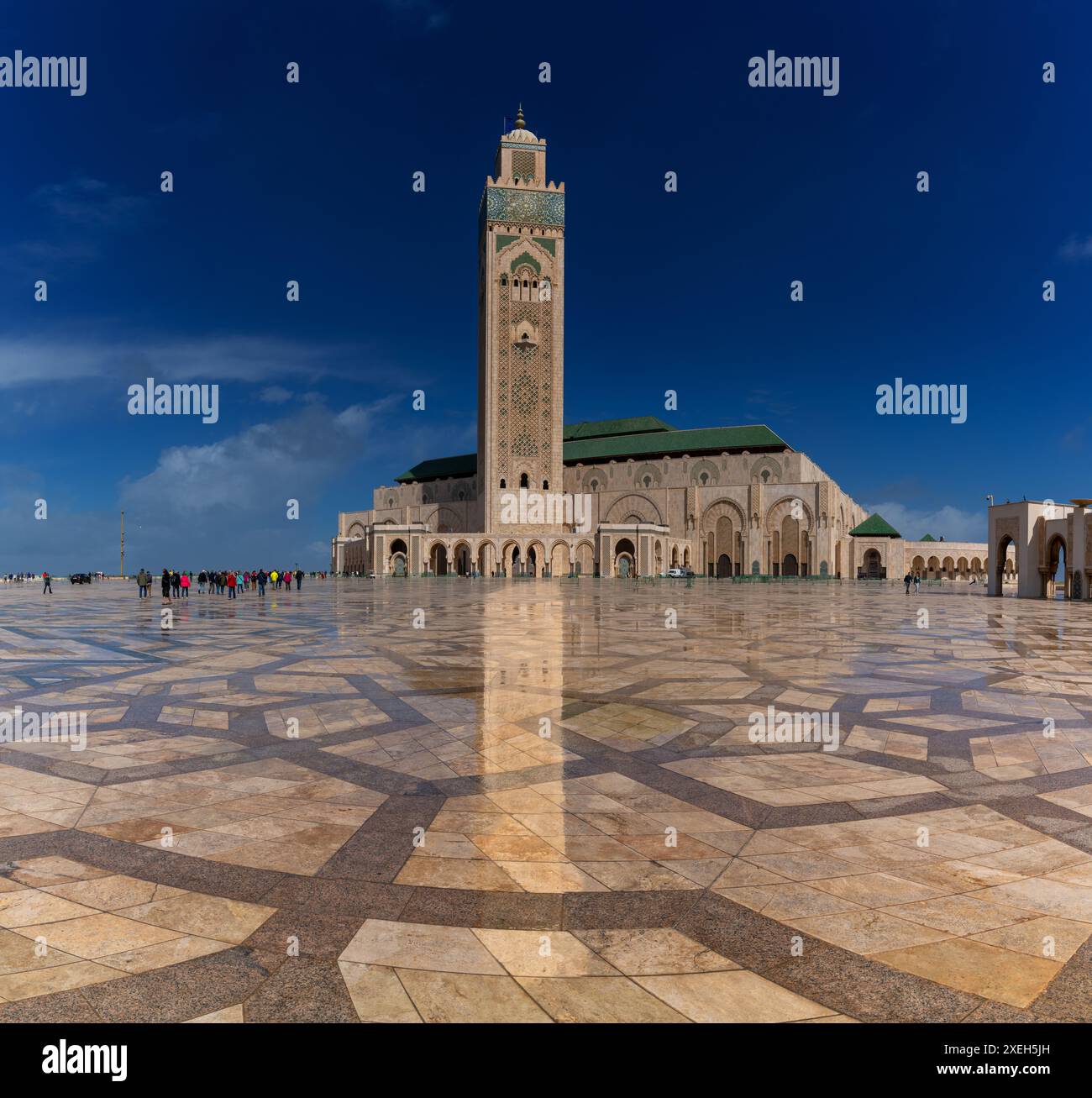 Vista dell'esterno e del minareto della Moschea di Hassan II a casablanca con riflessi sul marmo bagnato in primo piano Foto Stock