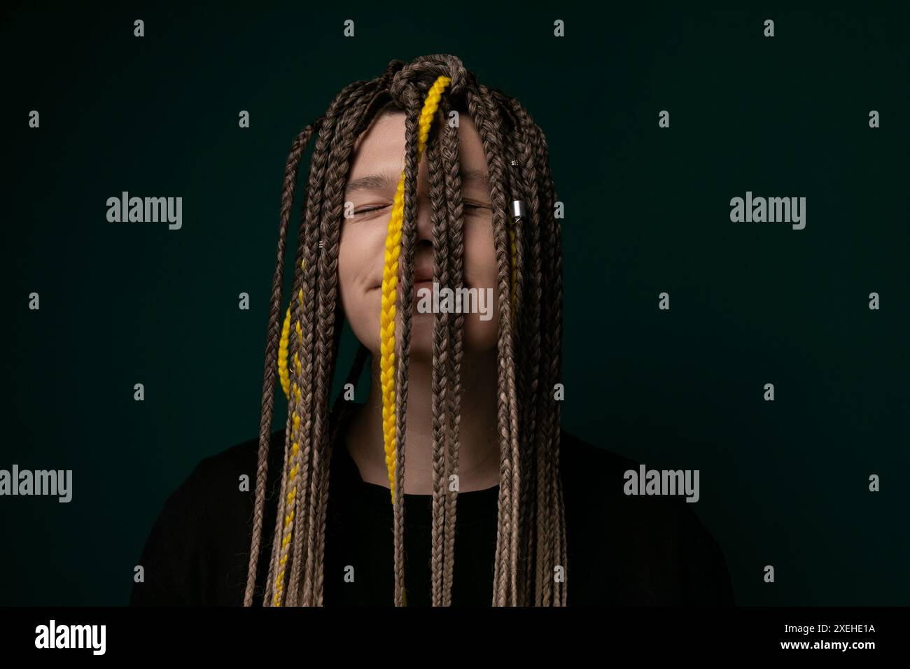Donna con lunghi Dreadlock davanti allo sfondo verde Foto Stock