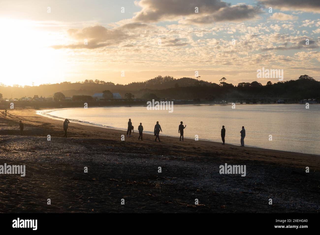 Persone che camminano al tramonto sulla spiaggia di te ti Bay a Waitangi, Bay of Islands, nuova Zelanda Foto Stock