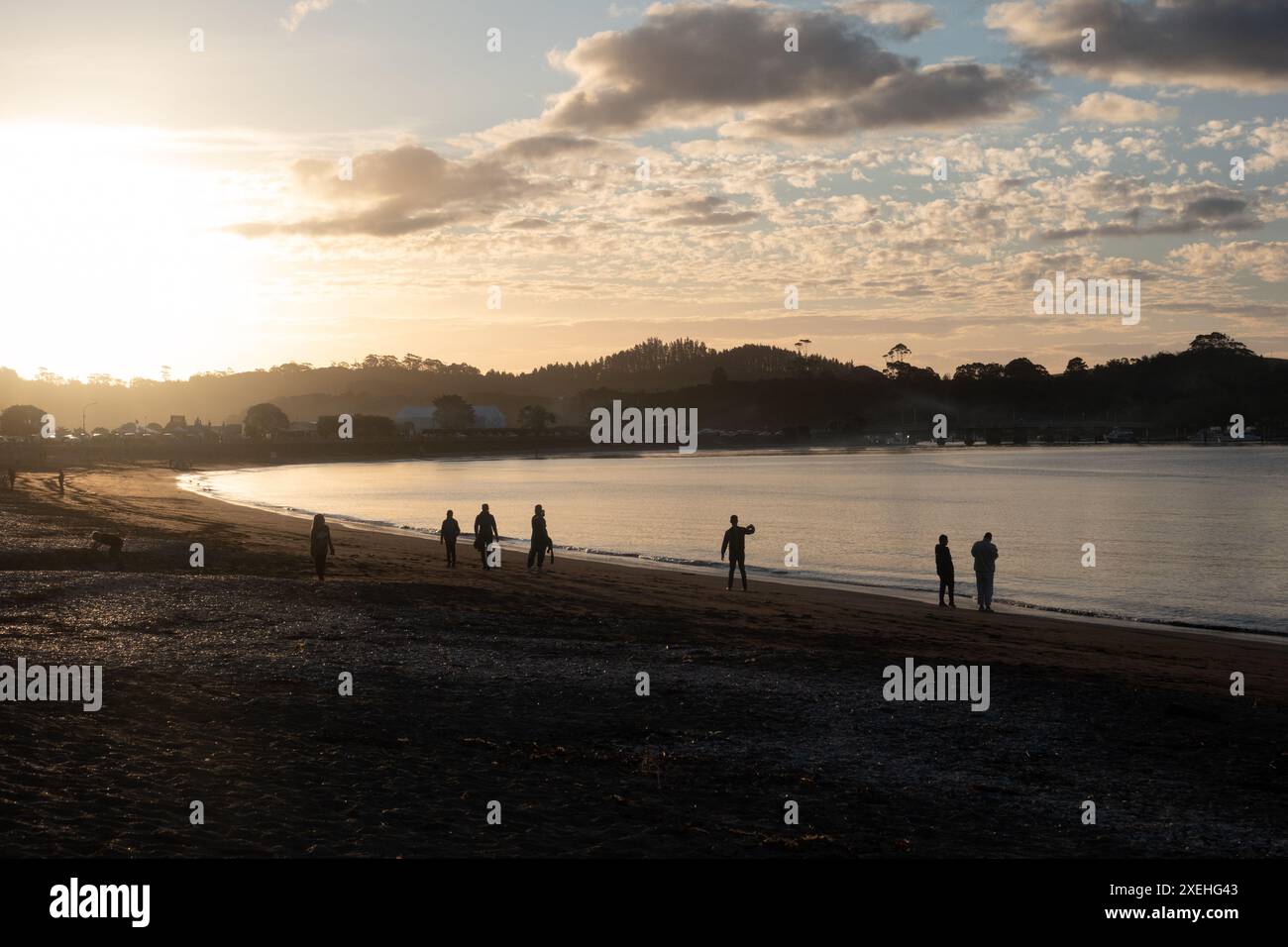 Persone che camminano al tramonto sulla spiaggia di te ti Bay a Waitangi, Bay of Islands, nuova Zelanda Foto Stock