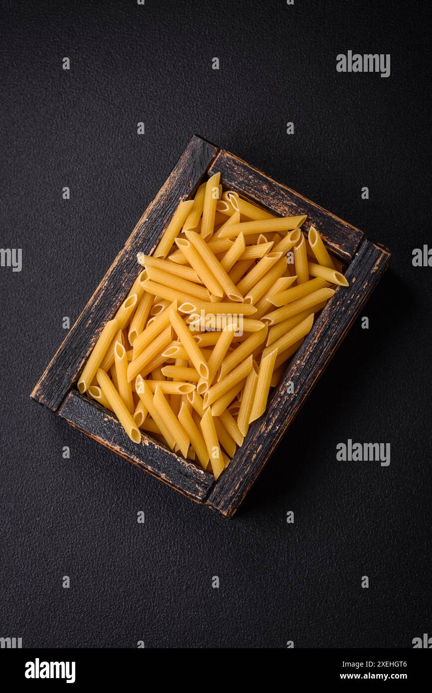 Penne crude da varietà di grano integrale con sale e spezie Foto Stock