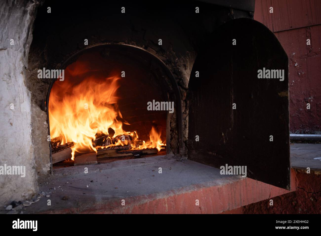 Fuoco e combustione di carboni nel forno a pietra. Forno in mattoni e argilla. Foto Stock