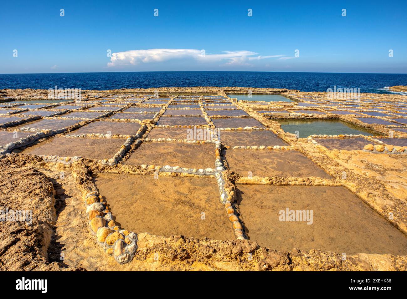 Saline tradizionali nella baia di Xwejni sulla spiaggia dell'isola di Gozo, Malta. Foto Stock