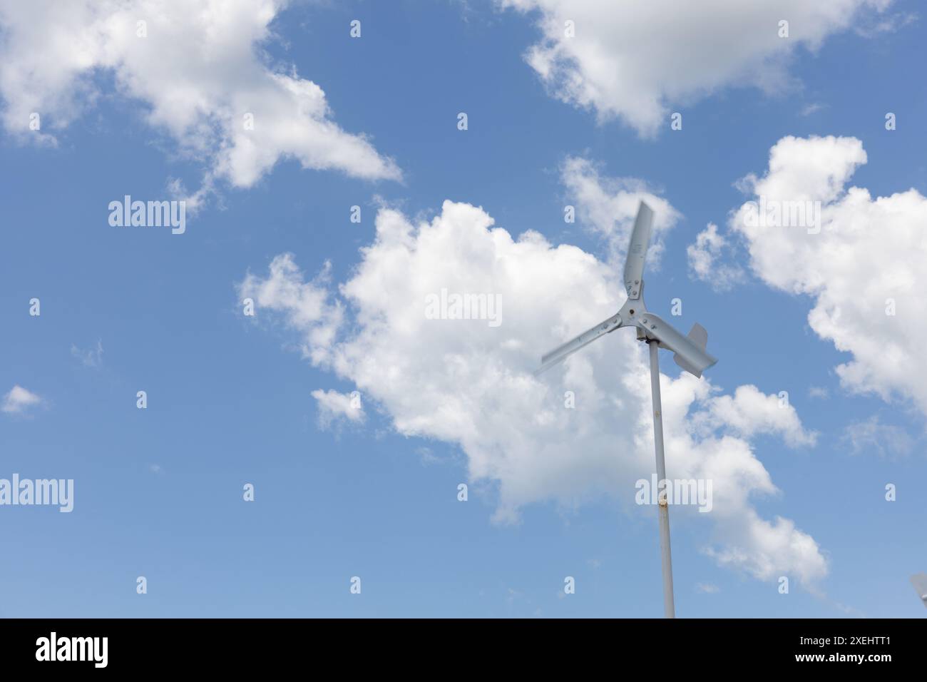 Turbina eolica moderna: Energia pulita e rinnovabile in un cielo blu, innovazione ecocompatibile per l'energia sostenibile e un futuro più verde Foto Stock