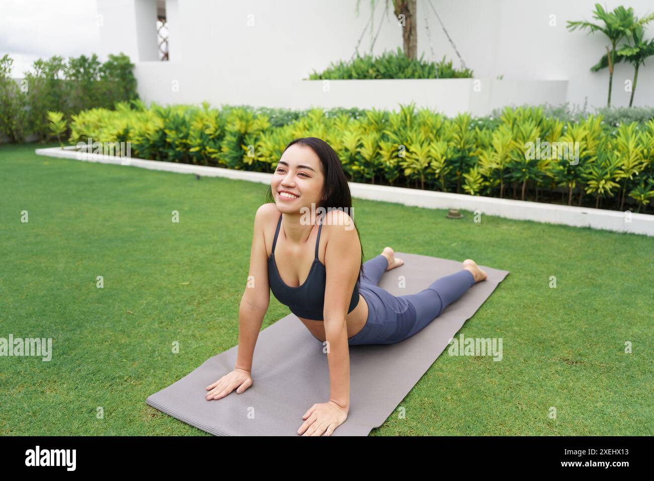 BeautifulÂ donna asiatica sicura di sé pratica yoga Â nel parco verde rilassarsi nella natura. Ritratto ragazza asiatica fare sereno sincero peacefulÂ Foto Stock