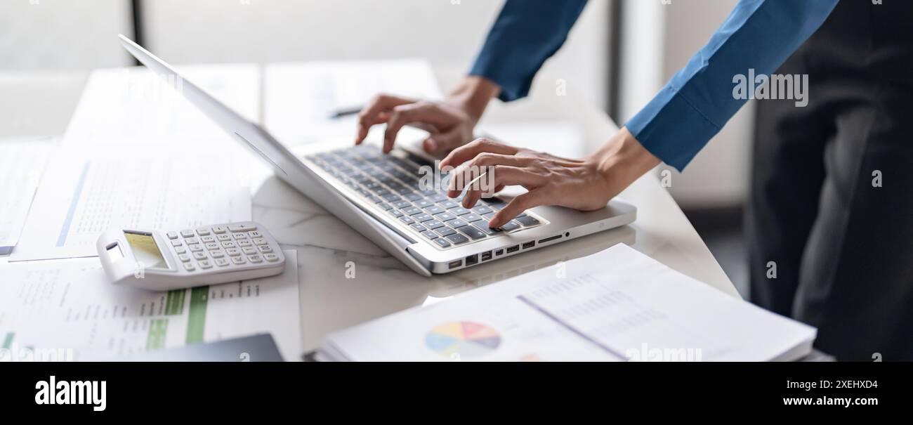 Lavorare utilizzando un computer portatile su un tavolo di legno. Mani che digitano su una tastiera.tecnologia concetto di e-commerce Foto Stock