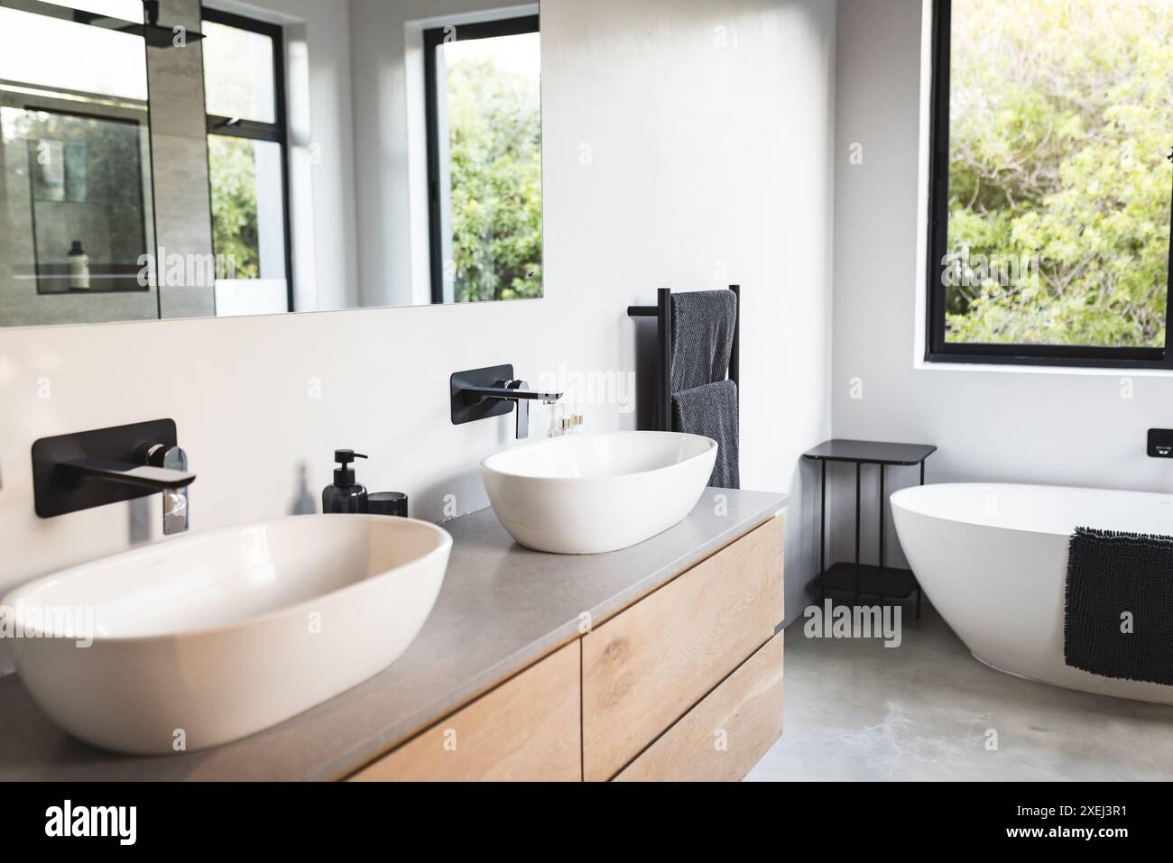 Bagno moderno con doppio lavabo, armadi in legno, vasca autoportante, spazio fotocopie Foto Stock