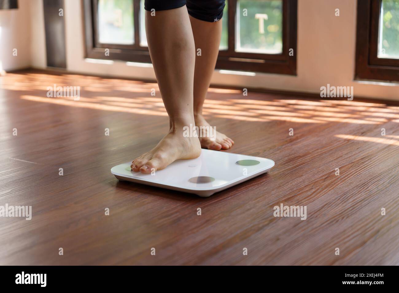 Dieta grassa e piedini graduati posizionati su bilance elettroniche per il controllo del peso. Strumento di misurazione in chilogrammi per il controllo della dieta Foto Stock