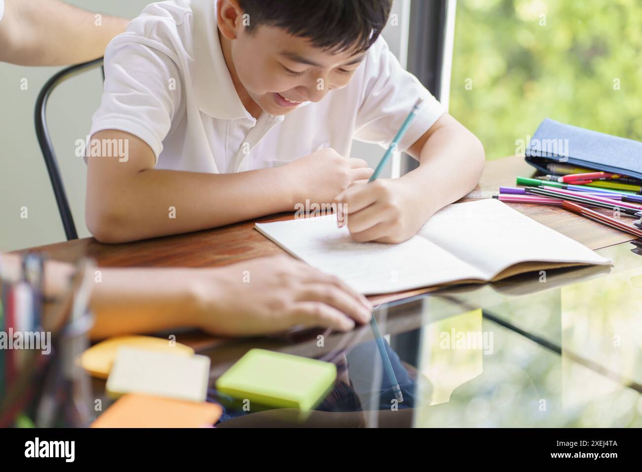 Il padre asiatico aiuta il figlio a fare i compiti per la scuola. studio dei bambini insieme concetto di scuola a casa ottenere aiuto per i compiti Foto Stock