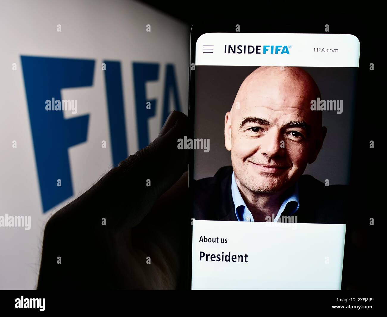 Persona che detiene un cellulare con il sito web della Federazione Internazionale di calcio (FIFA) con il logo. Messa a fuoco al centro del display del telefono. Foto Stock