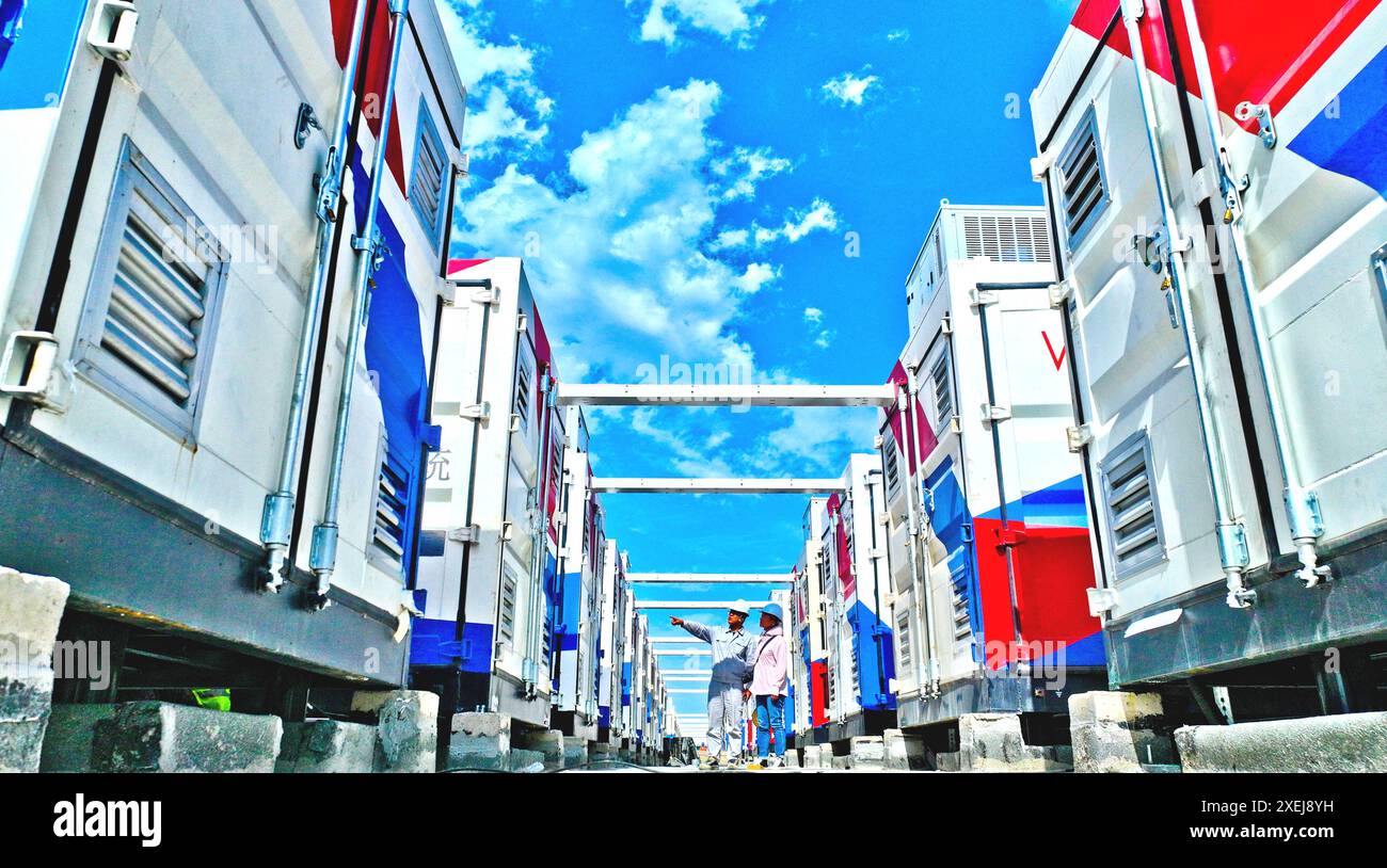 ZHANGYE, CINA - 27 GIUGNO 2024 - i tecnici controllano l'installazione e la messa in servizio delle apparecchiature di immagazzinamento dell'energia presso il cantiere di Energy T. Foto Stock