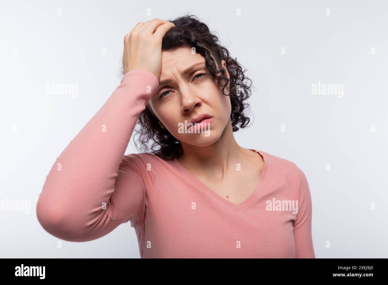 Ritratto di una donna riccia eccitata con un taglio di capelli corto in una camicetta rosa Foto Stock