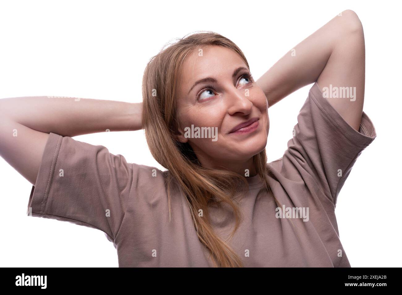 Donna europea spensierata con capelli biondi guarda in alto Foto Stock
