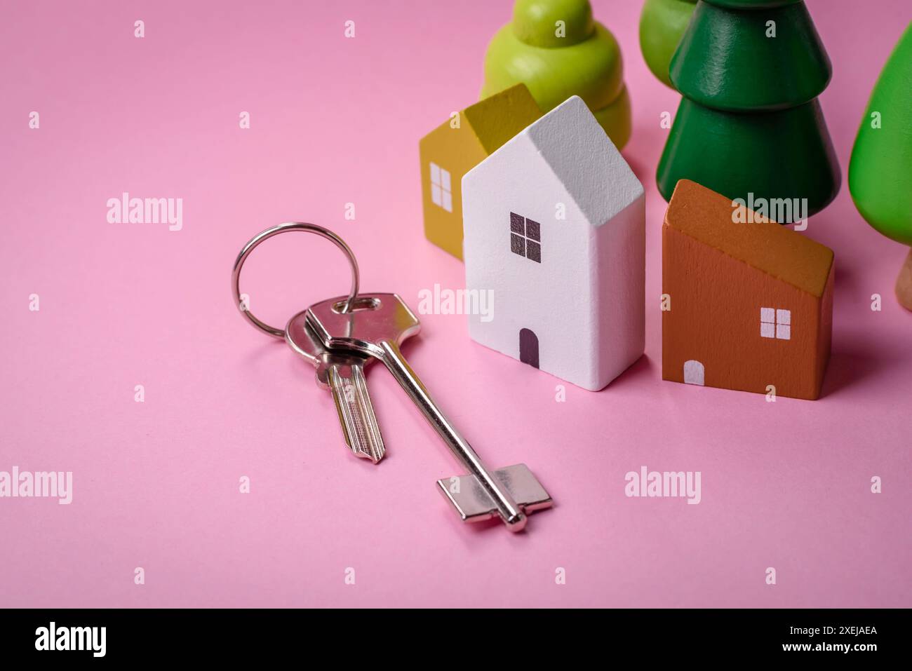 Una piccola casa di legno e chiavi come idea per investire nella propria casa e raggiungere l'obiettivo di acquistare immobili Foto Stock
