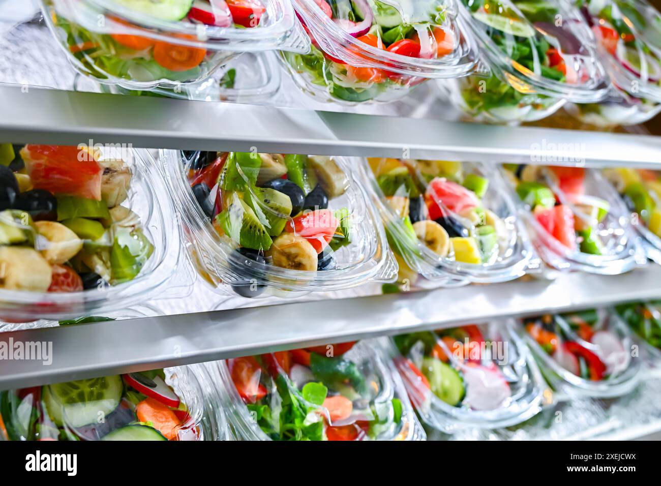 Scatole di plastica con insalate di frutta e verdura preconfezionate Foto Stock