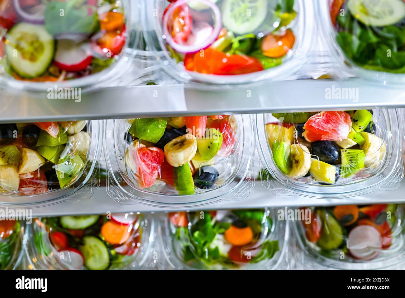 Scatole di plastica con insalate di frutta e verdura preconfezionate Foto Stock