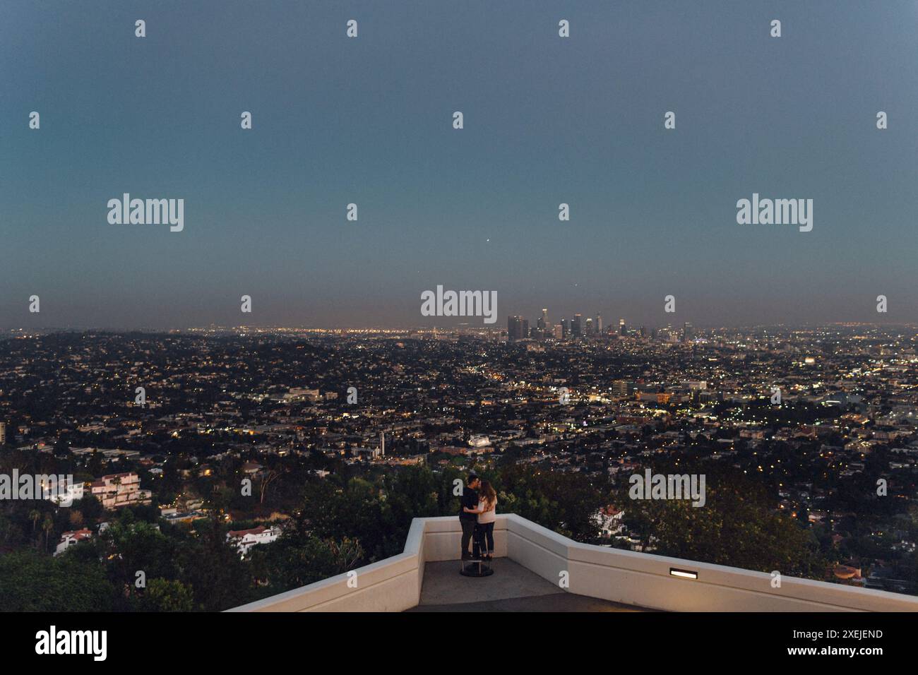 Abbracciare una coppia che guarda il centro di Los Angeles da un punto panoramico del parco Foto Stock