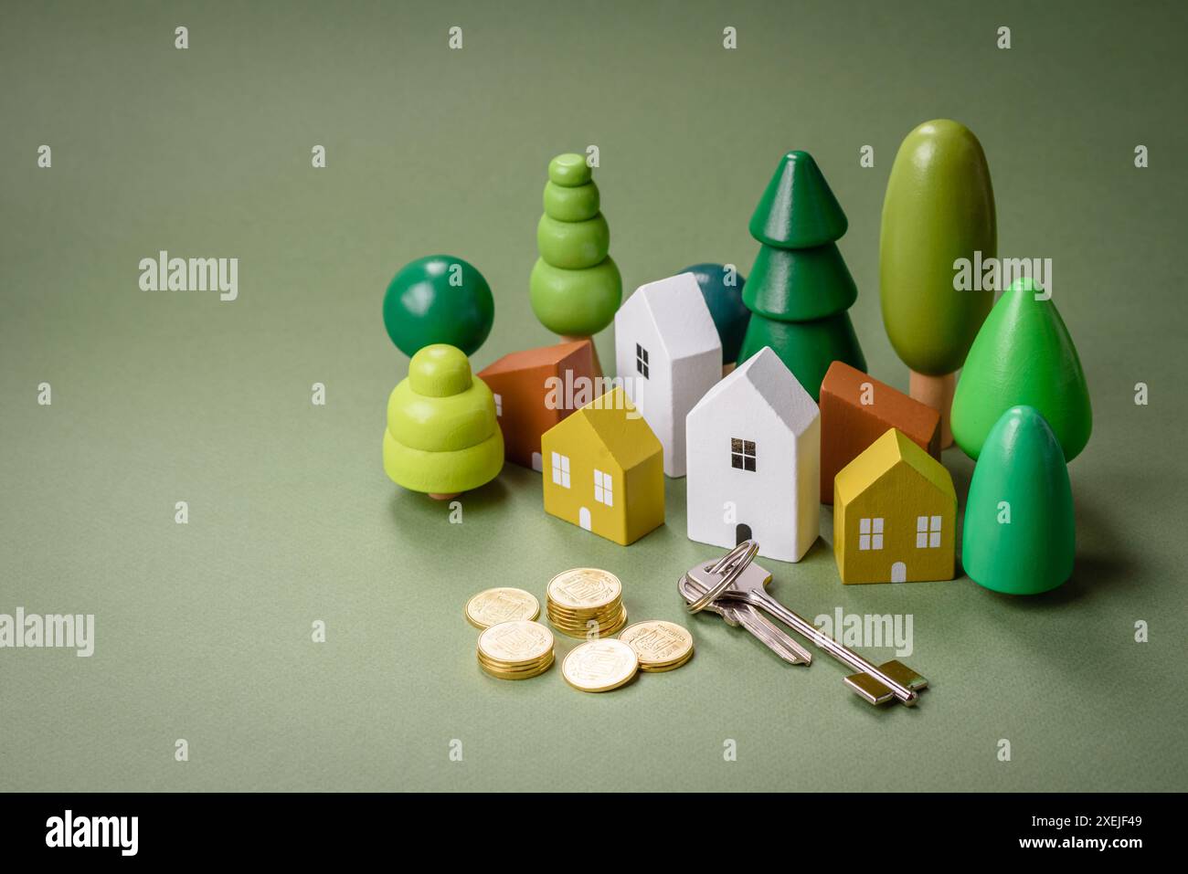 Una piccola casa di legno e chiavi come idea per investire nella propria casa e raggiungere l'obiettivo di acquistare immobili. Sfondo Foto Stock