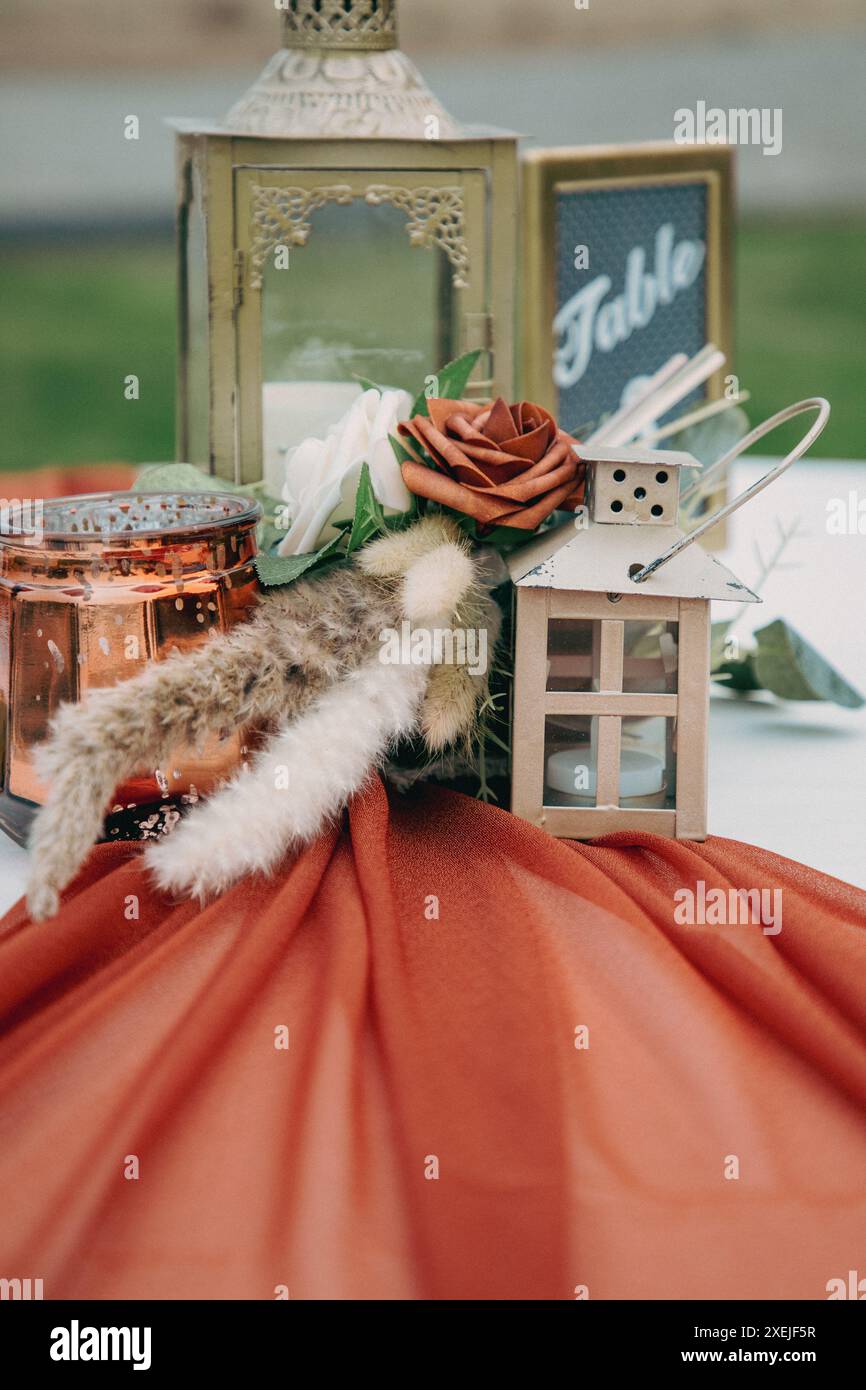 Elemento centrale del tavolo da nozze con lanterne, fiori e candele Foto Stock