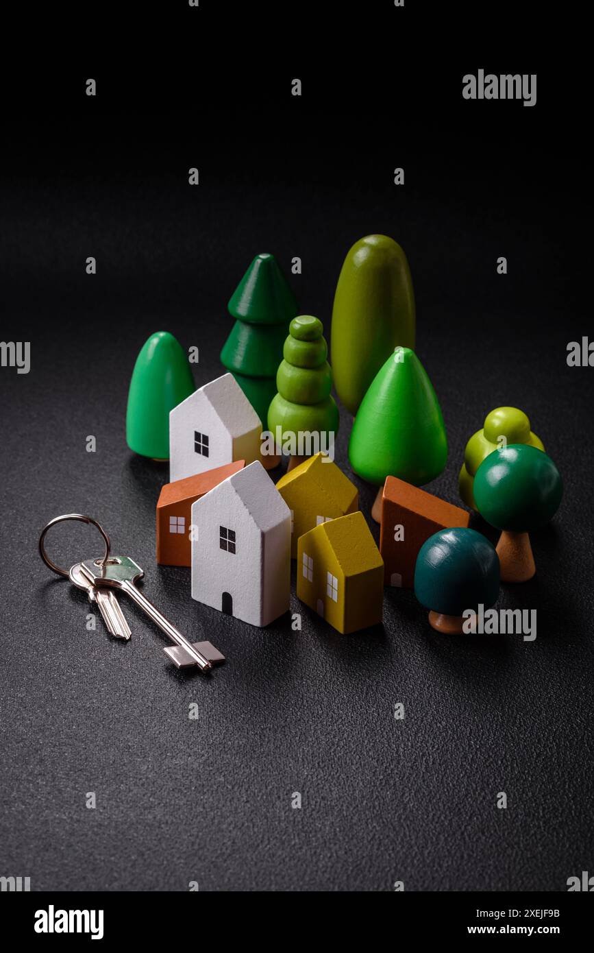 Una piccola casa di legno e chiavi come idea per investire nella propria casa e raggiungere l'obiettivo di acquistare immobili Foto Stock