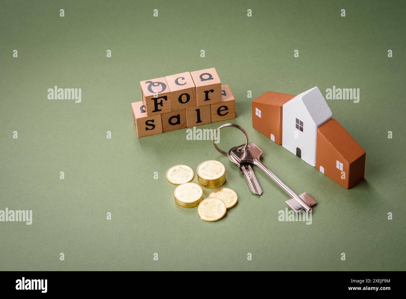 Una piccola casa di legno e chiavi come idea per investire nella propria casa e raggiungere l'obiettivo di acquistare immobili. Sfondo Foto Stock