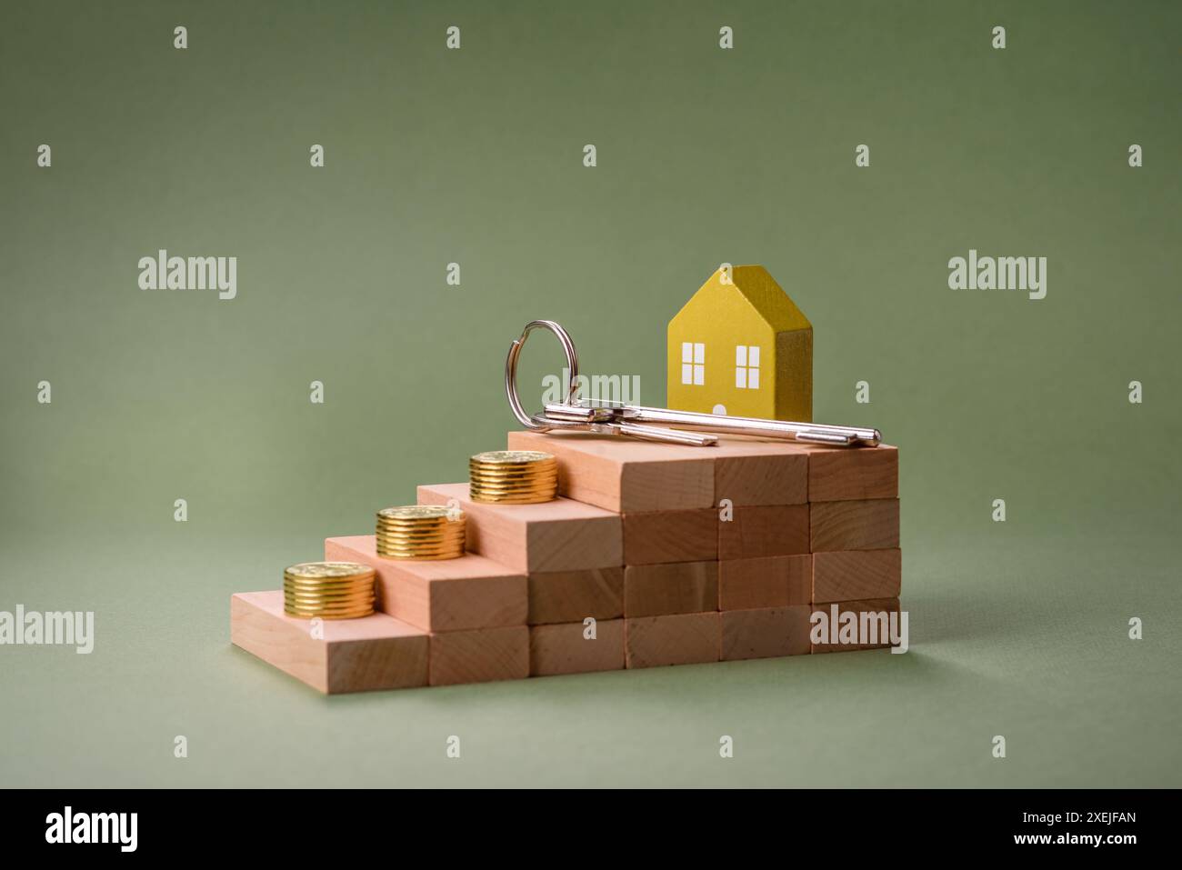 Una piccola casa di legno e chiavi come idea per investire nella propria casa e raggiungere l'obiettivo di acquistare immobili. Sfondo Foto Stock